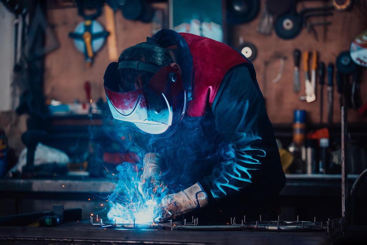 Welder erecting technical steel. Industrial steel welder in factory technical